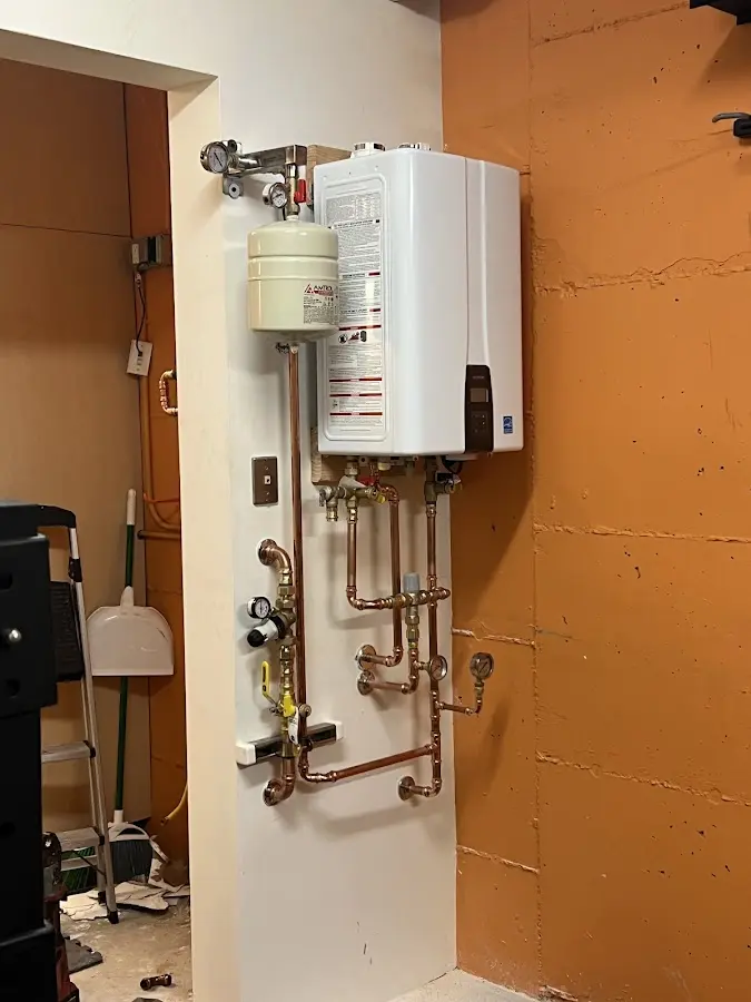 Plumbing technician inspecting water heater connections in Theodore